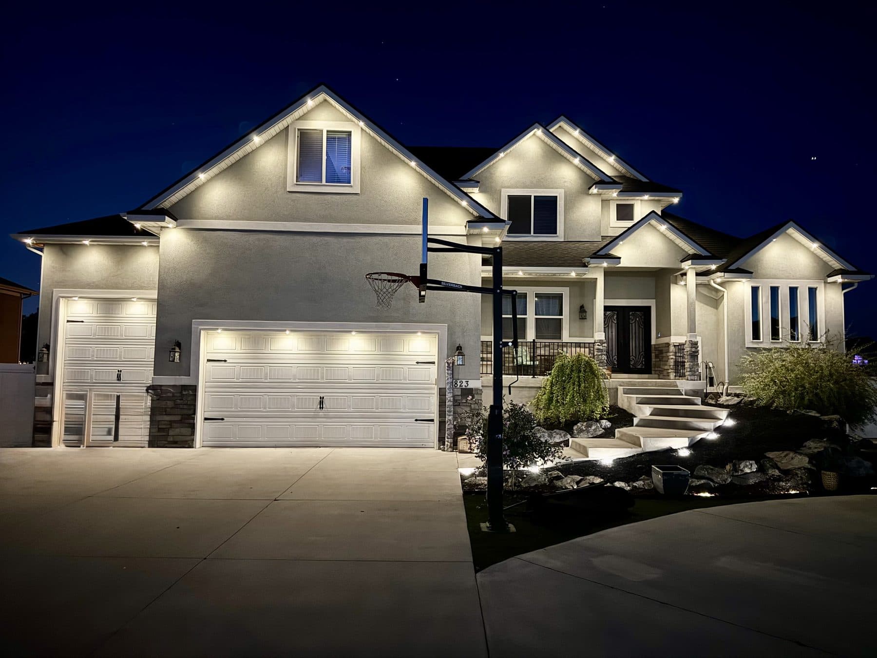 Stucco two-story home with permanent architectural lighting